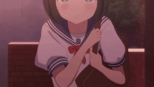 a girl in a sailor uniform holds a brown bag