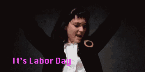 a woman is raising her arms in the air while wearing a black jacket and a white shirt .
