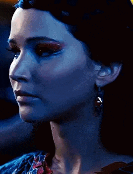 a close up of a woman 's face wearing earrings and a braided headband .