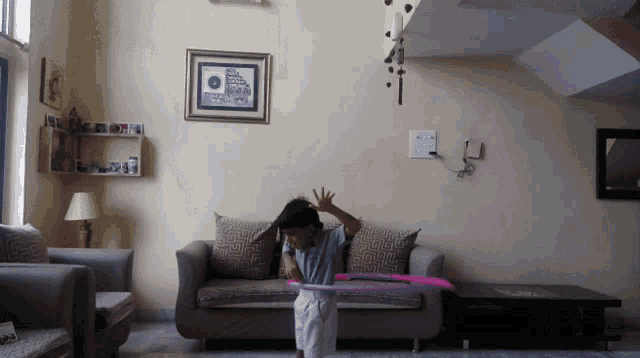 a boy is playing with a hula hoop in a living room