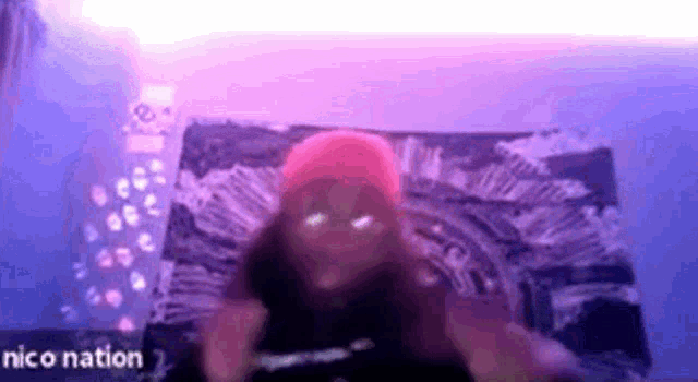 a person is laying on a bed with a purple light behind them and the words nico nation on the bottom .