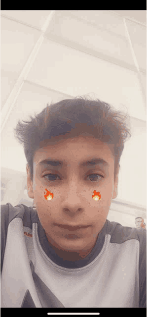 a young boy with freckles on his face is wearing a grey shirt