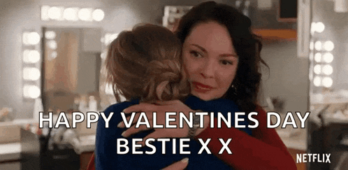 two women hugging each other in a room with the words `` happy valentine 's day bestie x x '' written on the screen