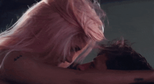 a woman with pink hair is being touched by a man .