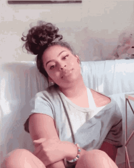 a woman with curly hair is sitting on a blue couch