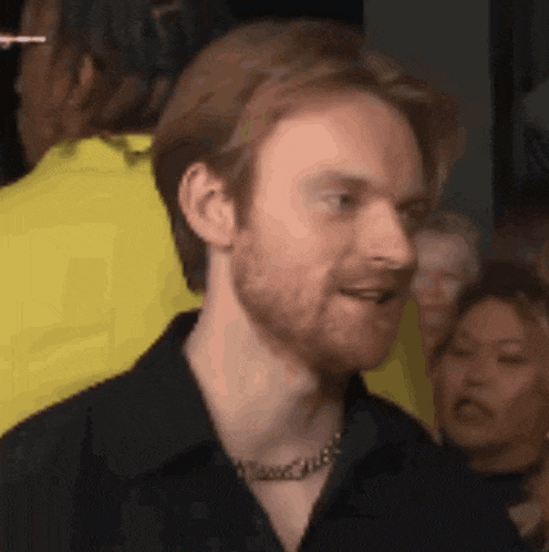 a man with red hair and a beard is wearing a black shirt .