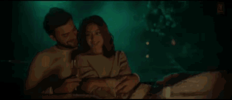 a man and a woman are sitting next to each other holding a glass of champagne .