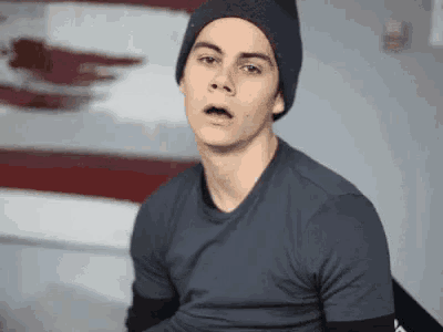 a young man wearing a beanie and a gray shirt