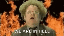 a man in a suit and tie is saying `` we are in hell '' in front of a fire .