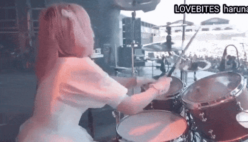 a girl with pink hair is playing drums in a band called lovebites haruna