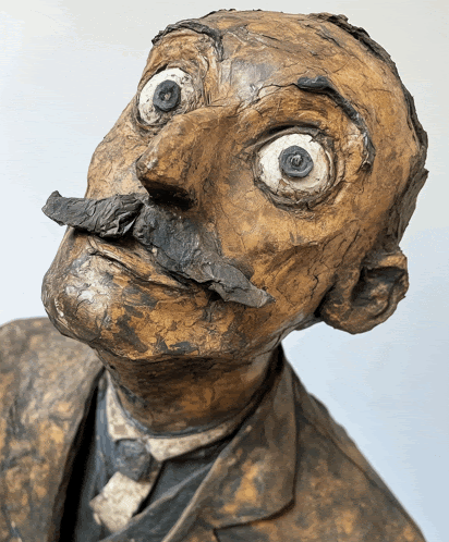 a close up of a statue of a man with a mustache and large eyes