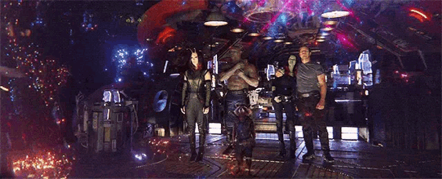 a group of people standing next to each other in a room with a galaxy in the background