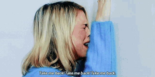 a woman in a blue sweater is crying and says take me back