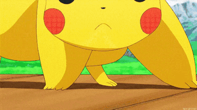 a close up of a pikachu standing on its hind legs on a wooden surface .