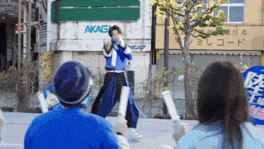 a man stands in front of a building with the word akagi on it
