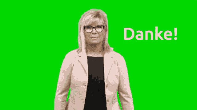 a woman wearing glasses stands in front of a green background that says danke