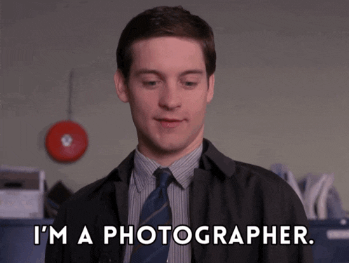 a man in a suit and tie says " i 'm a photographer .. "