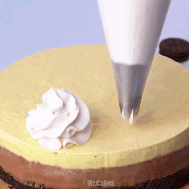 whipped cream is being piped on top of a cake that says mr.cakes