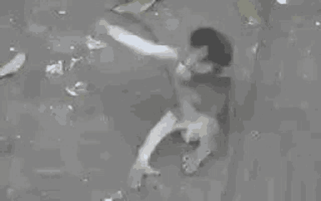 a black and white photo of a monkey hugging a man in the water .