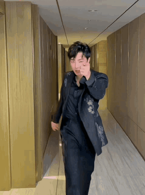 a man in a suit is walking down a hallway