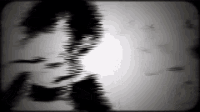 a black and white image of a person 's face with a blurred background