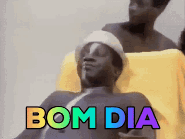 a man in a hat and sunglasses is laying in a chair with the words bom dia .