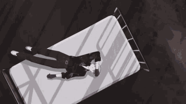 a man is laying on a bed with his head on his arm