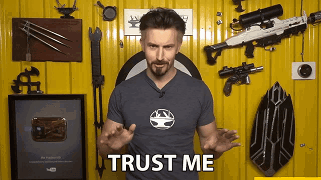 a man is standing in front of a yellow wall and says " trust me "