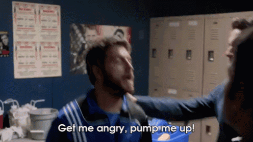 a man in a blue jacket is being punched in the face by another man in a locker room .