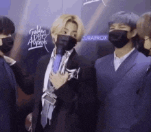a group of men in suits and masks are standing next to each other .