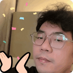 a man wearing glasses giving a thumbs up