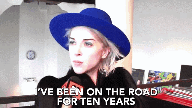 a woman wearing a blue hat and a black coat says i 've been on the road for ten years