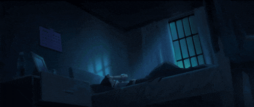 a person laying on a bed in a dark room