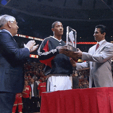a man in a chicago jersey holds a trophy