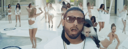 a man with a monkey on his shoulder is surrounded by women