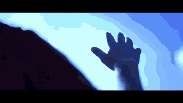 a person 's hand is reaching up towards the sky
