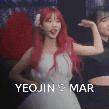 a woman with red hair is wearing a white dress and a flower in her hair while dancing .