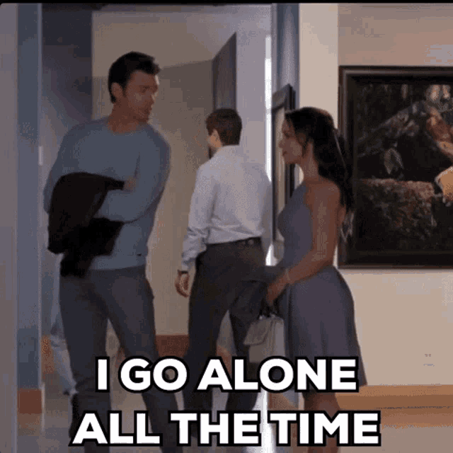 a woman in a purple dress says " i go alone all the time " while standing in a hallway