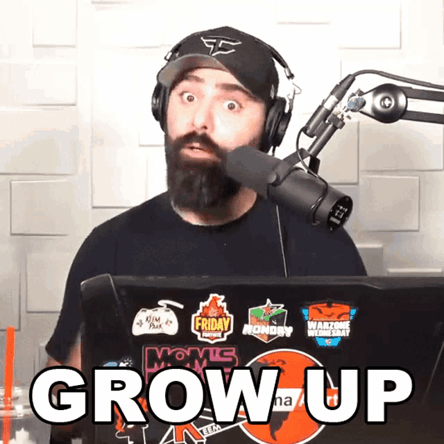 a man wearing headphones and a hat stands in front of a microphone with the words grow up on the screen