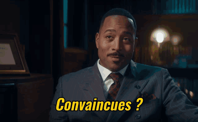 a man in a suit says " convaincues " in yellow letters