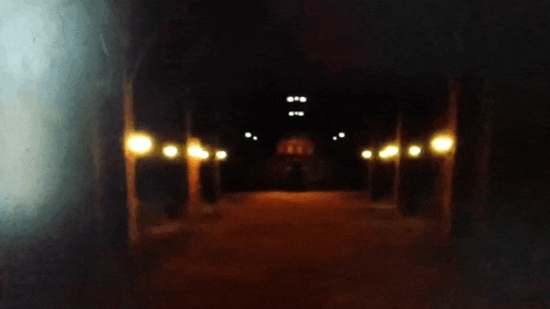 a blurry picture of a skeleton with a large head walking through a dark tunnel .