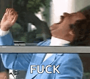 a man in a blue suit is standing in front of a window with his hands up and the word fuck written on the glass .