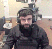 a man with a beard is wearing headphones and a vest