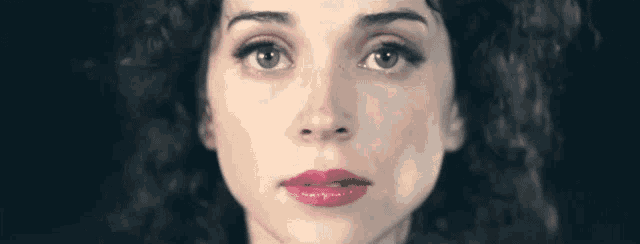 a close up of a woman 's face with red lipstick on her lips .