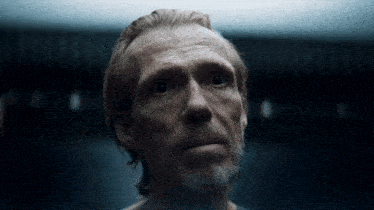 a man with a beard is looking up at the camera