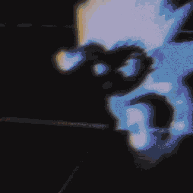 a blurry image of a person 's face with a blue light behind them