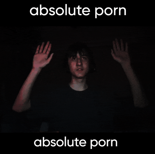 a man in a dark room with his hands up and the words absolute porn above him