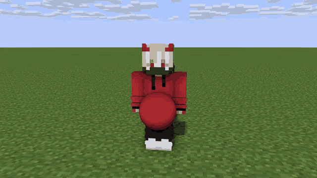 a person in a red hoodie with horns is standing in a field
