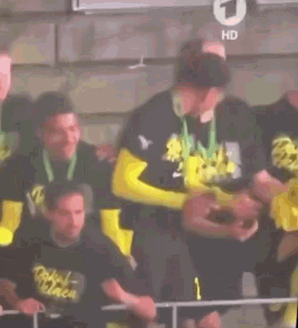 a group of men are standing next to each other in a stadium and one of them is wearing a medal .