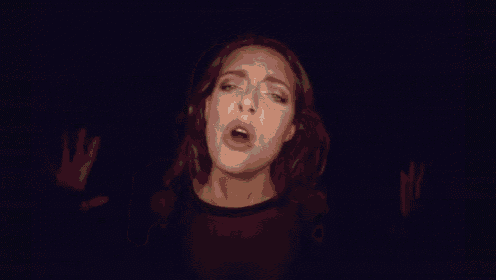 a woman is walking down a dark hallway with a sign that says ' a ' on it